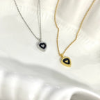 Gold and silver heart-shaped pendant necklaces on white textured background