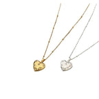 Gold and silver heart pendant necklaces with small crystal accents on white background.