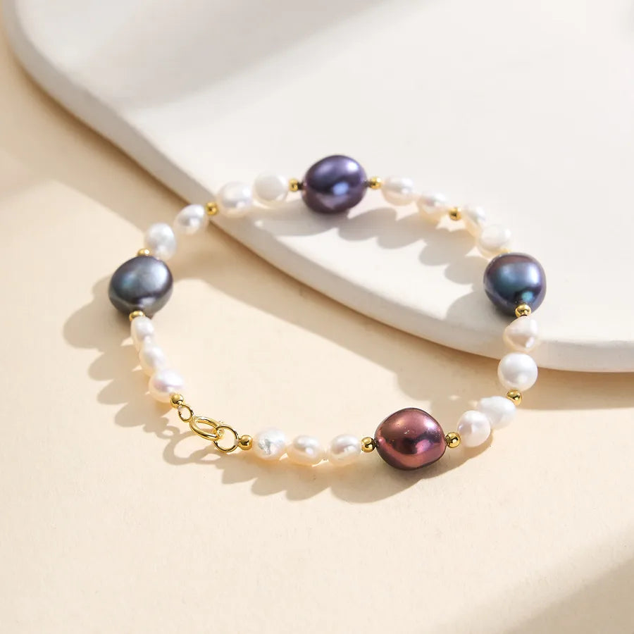 Elegant bracelet with multicolor pearls, gold accents, and white freshwater pearls