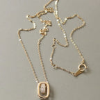 18K gold plated necklace with oval pendant and cubic zirconia details on gray background