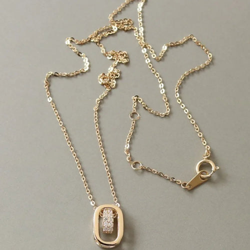 18K gold plated necklace with oval pendant and cubic zirconia details on gray background