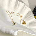 Gold heart pendant necklace with black center on a scalloped white dish