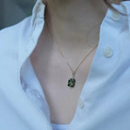 18K gold plated chain necklace with green gemstone pendant worn over a white shirt