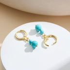 Gold hoop earrings with turquoise beads, demi-fine jewelry on white display